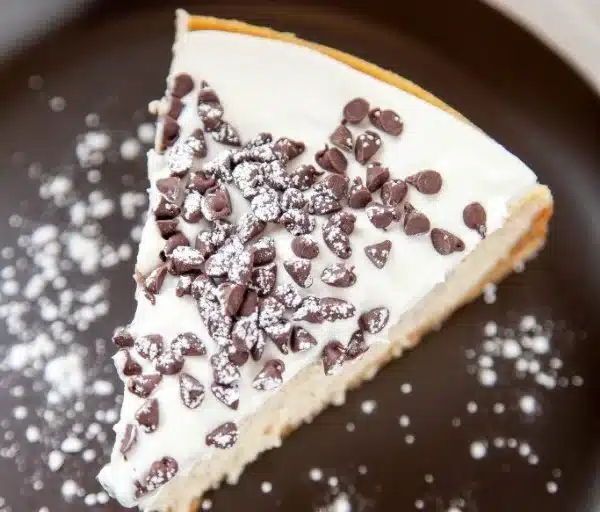 Delicious cannoli cheesecake with a creamy filling and a cannoli shell topping.