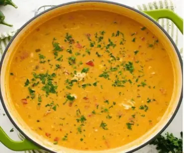 Bowl of delicious Chicken Enchilada Soup garnished with cilantro and cheese.