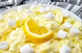 Bowl of Classic Lemon Fluff Salad with lemon slices and whipped cream