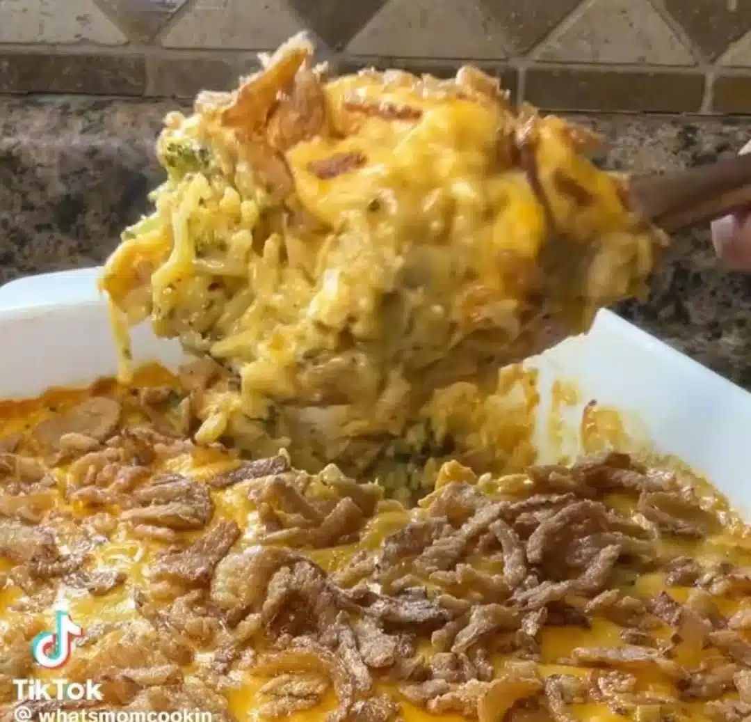 Cheesy chicken broccoli casserole served in a baking dish with melted cheese on top.
