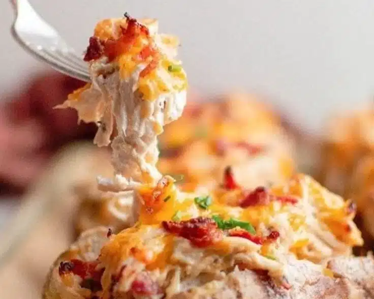 Crack chicken stuffed baked potatoes topped with cheese and herbs