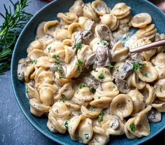 Plate of creamy mushroom marsala pasta garnished with fresh herbs