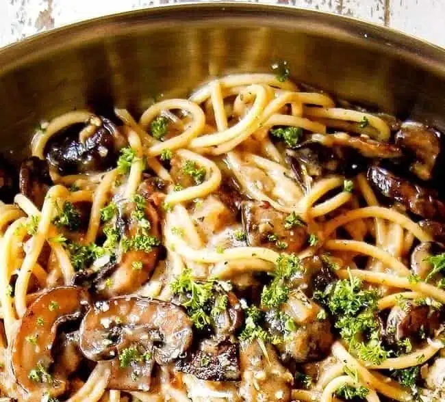 Creamy mushroom pasta dish with sauce and ingredients ready to serve.