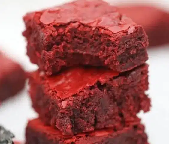 Decadent red velvet brownies served on a plate, topped with cream cheese frosting.