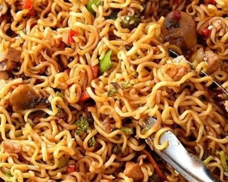 Bowl of easy chicken ramen stir fry topped with vegetables and herbs