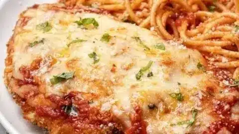 Plate of easy oven baked chicken parmesan with tomato sauce and cheese.