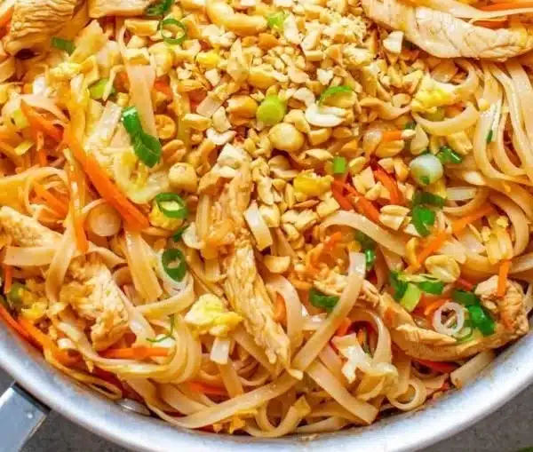Delicious Chicken Pad Thai served with fresh lime and peanuts