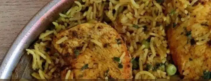 Plate of Mediterranean Chicken and Rice garnished with herbs and vegetables
