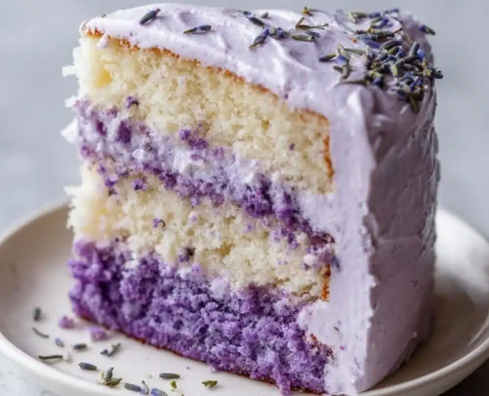 Moist lemon lavender cake with floral frosting and garnishes.