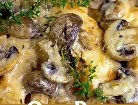 Creamy Mushroom Asiago Chicken dish with mushrooms and cheese on a plate.