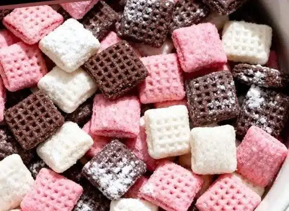 Delicious Neapolitan Puppy Chow dessert made with chocolate, peanut butter, and powdered sugar.