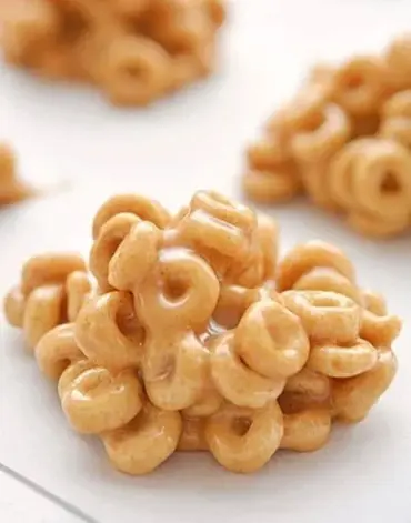 Delicious Peanut Butter Cereal Bites snack on a plate topped with crunchy cereal.