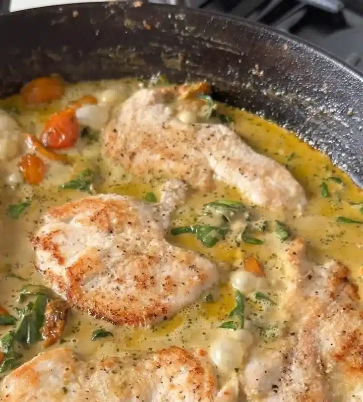 Pesto Chicken with Roasted Tomatoes and Spinach served on a white plate