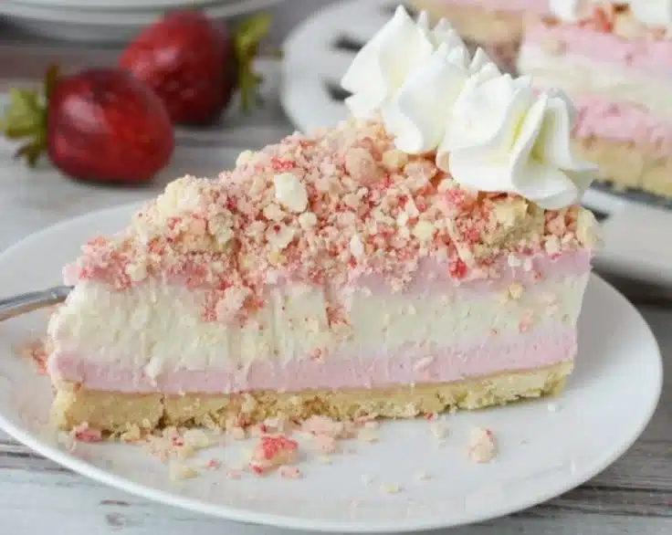 Delicious Strawberry Crunch Cheesecake garnished with fresh strawberries and crunchy topping.