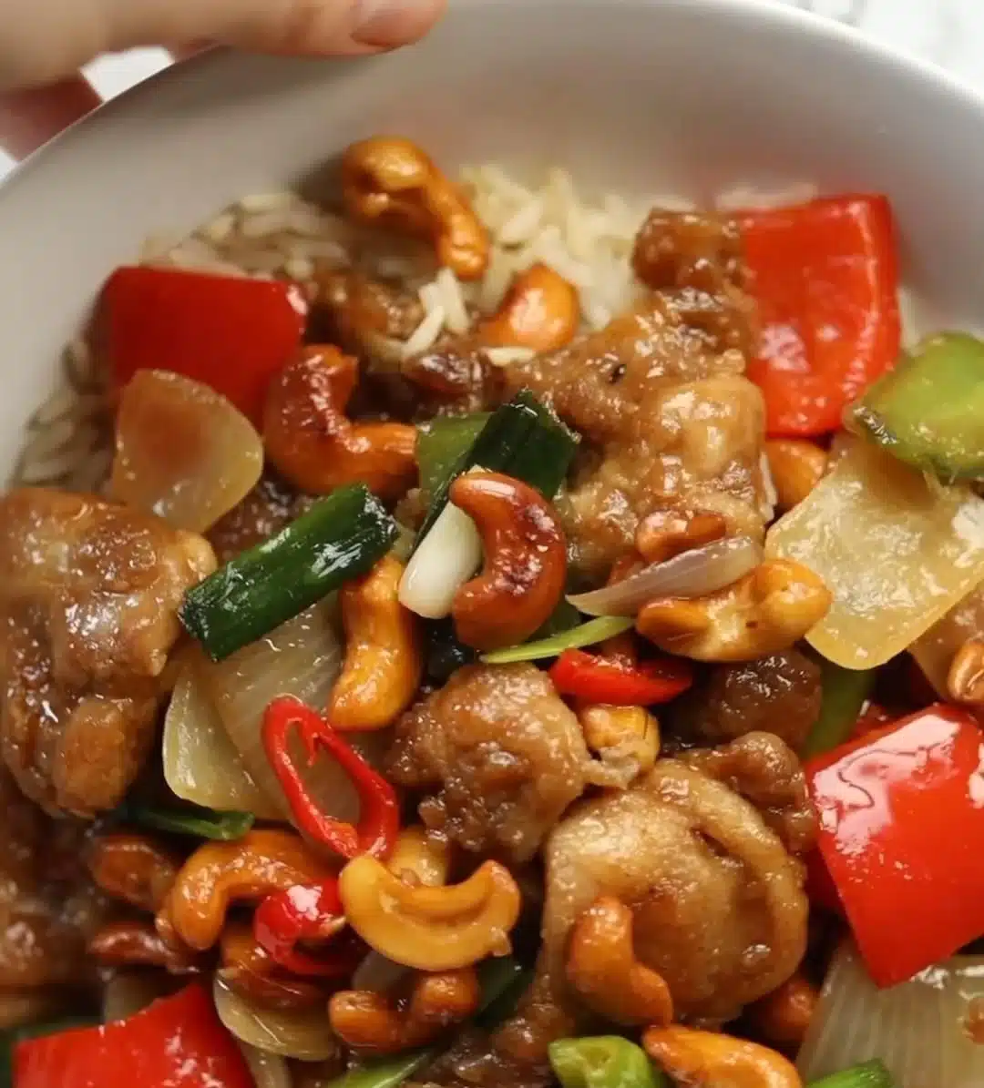 Delicious Thai Cashew Chicken served with colorful vegetables and cashews