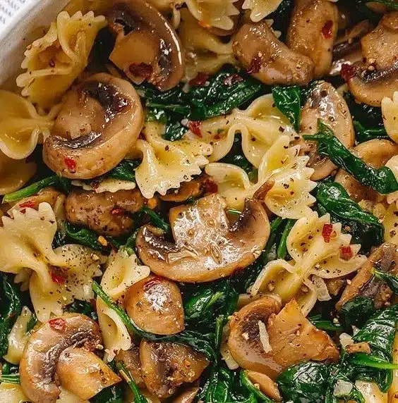 Delicious mushroom spinach pasta served in a skillet with Parmesan cheese